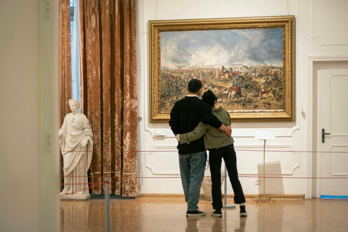 a man and a woman standing in front of a painting